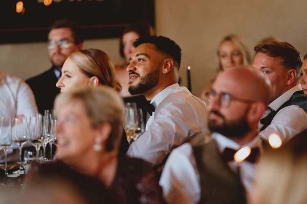 Men in audience watching speeches smiling