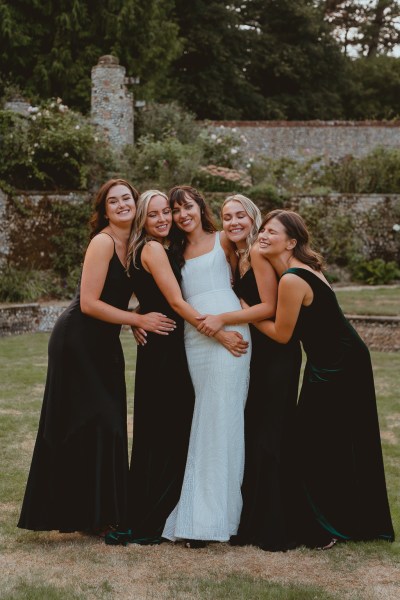 Bride and bridesmaids in black exterior garden shot