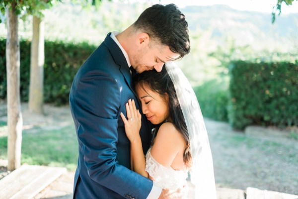 Bride and groom hug and embrace in garden