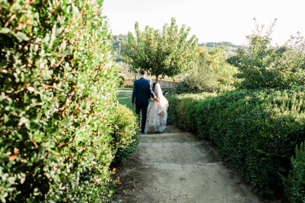 Bride and groom walking down steps in garden down