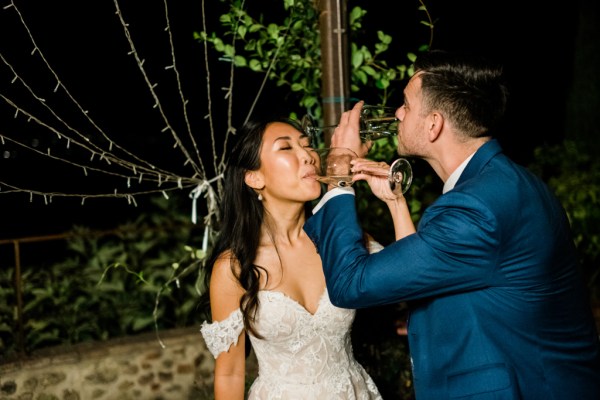 Bride and groom drinking from glass of wine