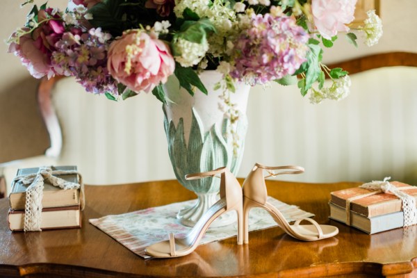 Close up of bridal heels shoes and bouquet of flowers