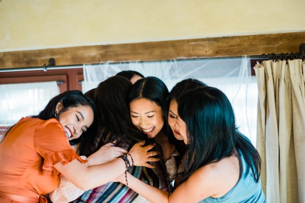 Friends bridesmaids and bride embrace emotional moment hug