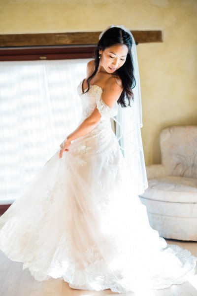 Bride shows off dress poses inside room interior shot