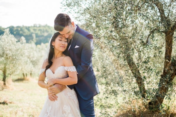 Bride looks at groom over shoulder in garden