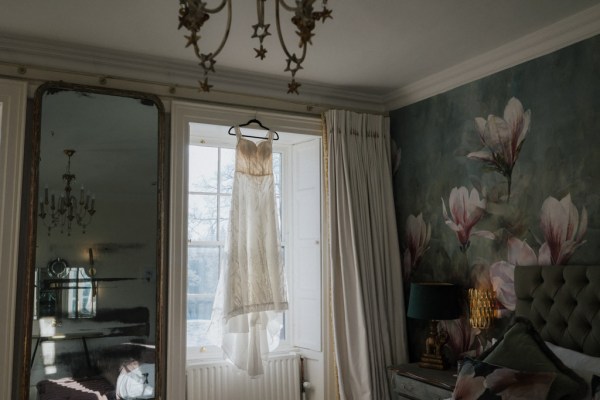 Bridal gown wedding dress hanging at window