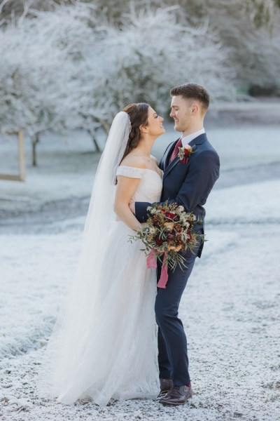 Bride and groom exterior shot looking at each other going in for a kiss