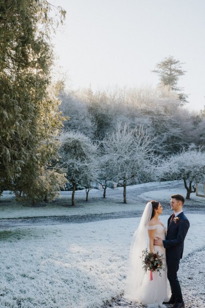 Bride and groom exterior shot looking at each other going in for a kiss