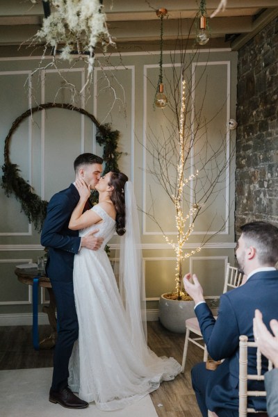 Bride and groom kiss at alter