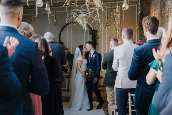 Bride and groom kiss in front of guests