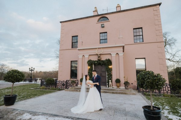 Bride and groom exterior wedding venue pink