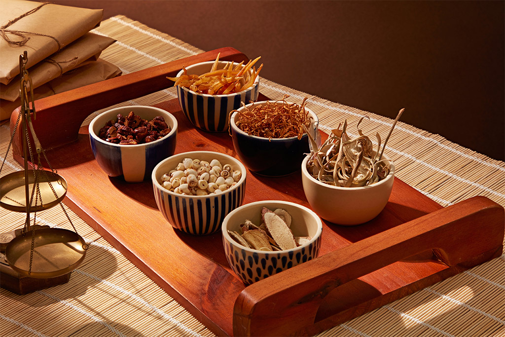 Herbal medicine concept with bowls of dried chopper herbs and spices on the wooden tray, Traditional Chinese Medicine. Photo by Shutterstock