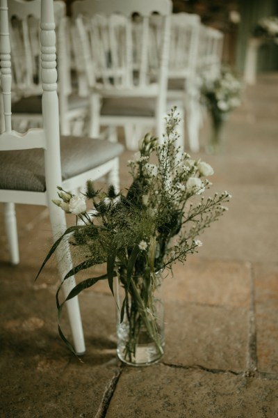 Close up of roses white bouquet flowers in vase beside white chair