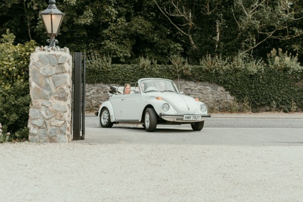 Father drives white wedding car with bride inside