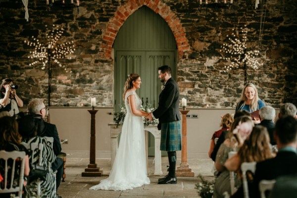 Bride and groom stand at the alter together