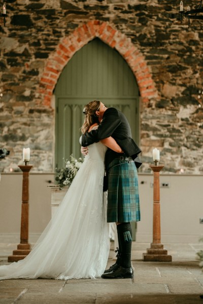 Bride and gorom hug at the alter