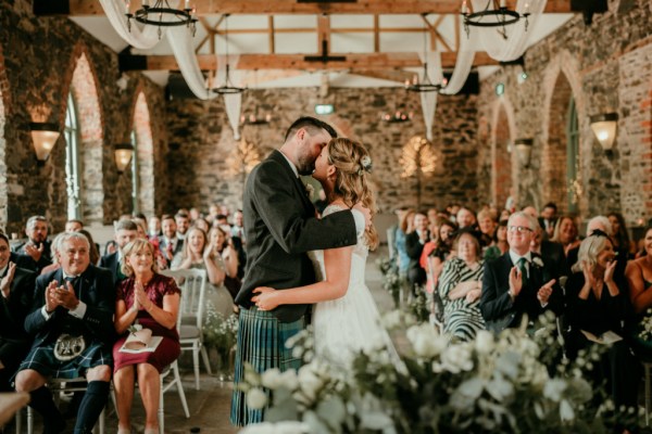 Bride and gorom kiss at the alter