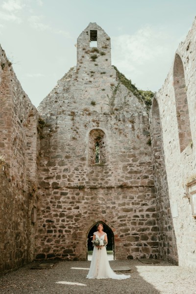 Bride standing in courtyard to castle