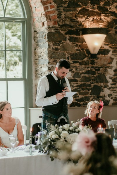 Groom reads speech to bride and guests