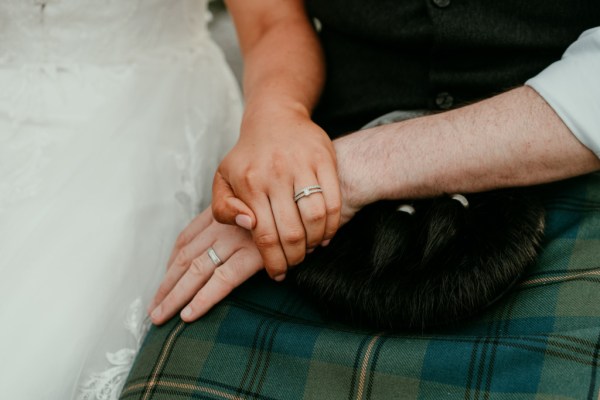 Bride and groom hand over hand wedding band details