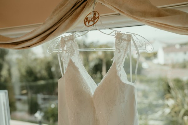 White bridal gown dress hanging in front of landscape view close up