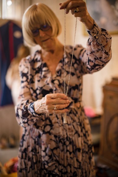 Older woman mother holding up silver necklace