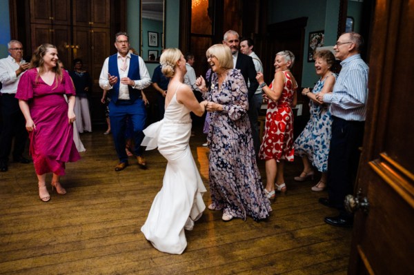 Atmosphere dancing shot of guests and bride on the dancefloor