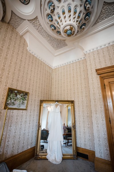 Dress hanging at mirror bridal gown