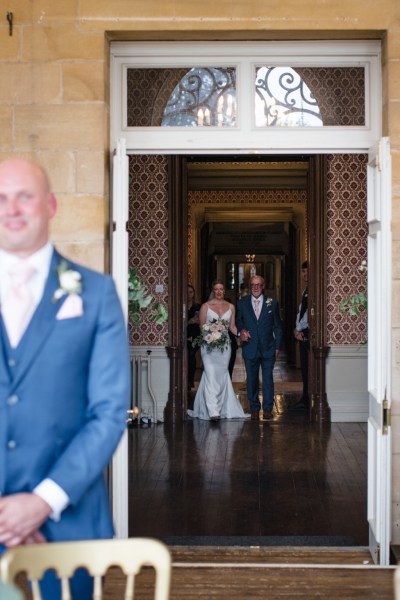 Groom awaits the bride as father walk her down the aisle