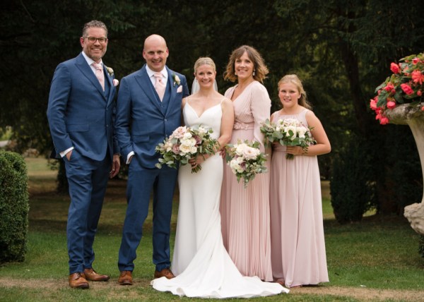 Family shot of bride groom bridesmaids and groomsman best man