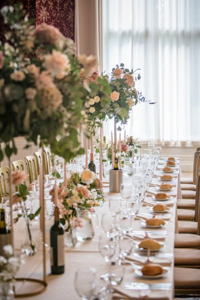 Roses flowers bouquet sitting on tables candles lit bottle of wine