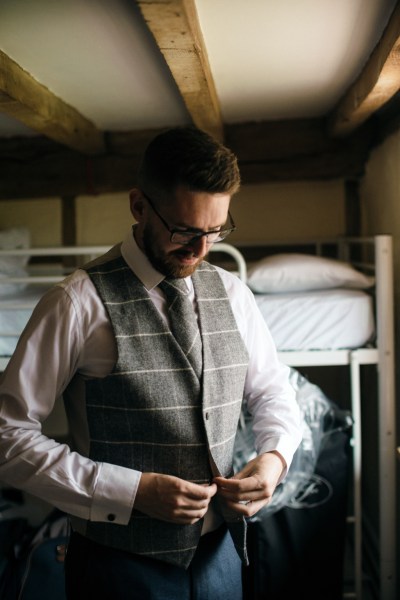 Groom wearing waistcoat is getting ready for the wedding