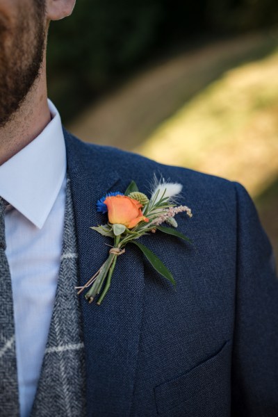 Close up of orange flower pin suit jacket