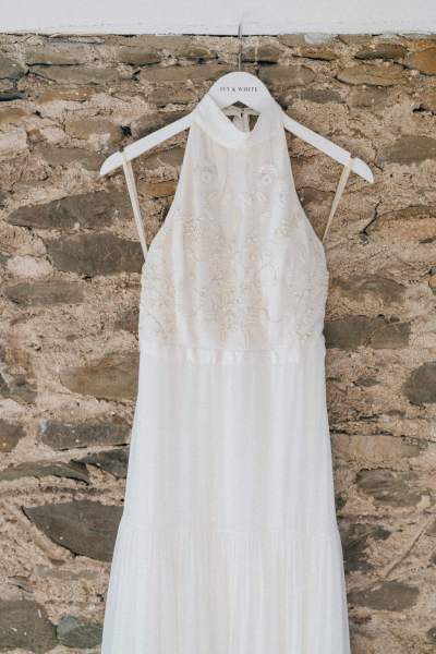 Bridal dress gown hanging in front of bricked wall