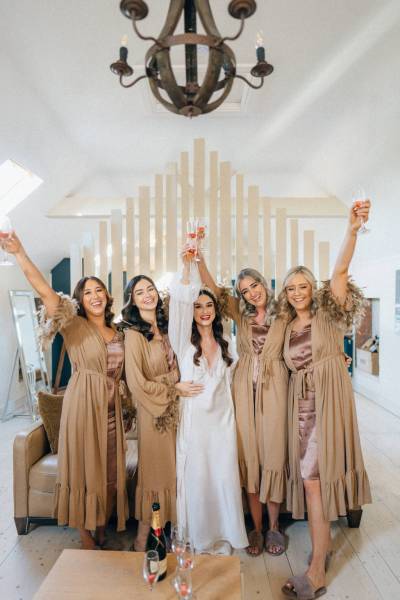 Hands in the air bride and bridesmaids celebrate before ceremony