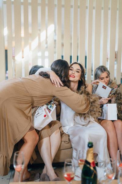 Bride and bridesmaids sit and open gifts