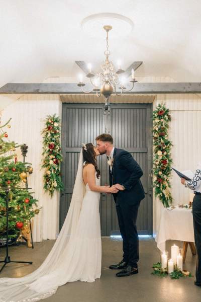 Bride and groom at alter to ceremony kiss kissing and holding hands