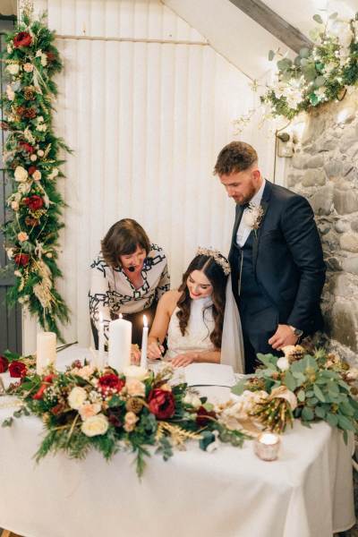 Mother bride and groom signing marriage cert