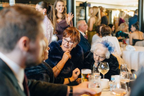 Atmosphere shot guests at table drinking talking