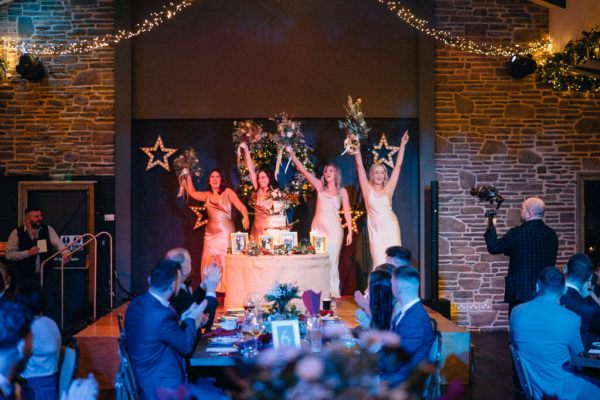 Interior dining room bride and bridesmaids surrounding wedding cake