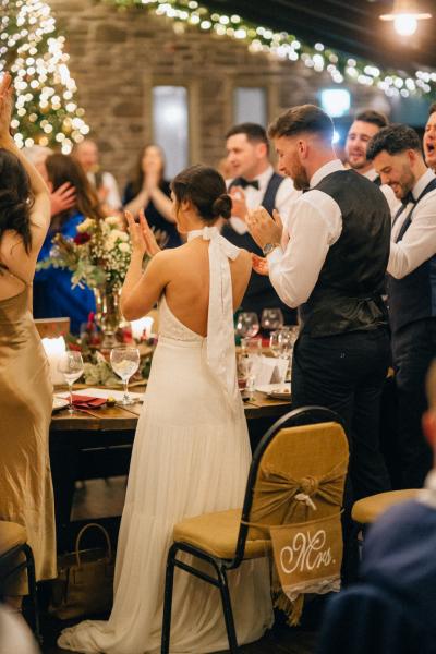 Bride and groom clapping with guests