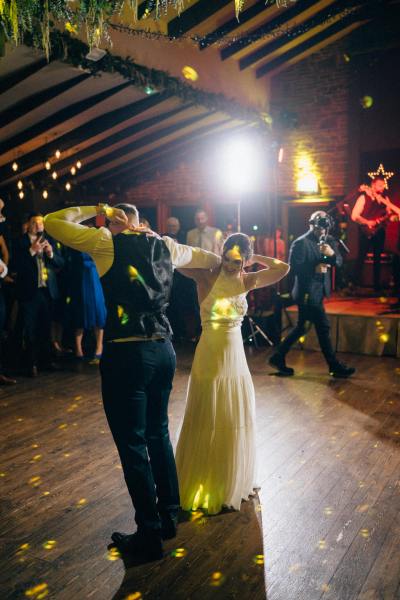 Bride and groom enter ballroom hands in the air first dance dancefloor dancing