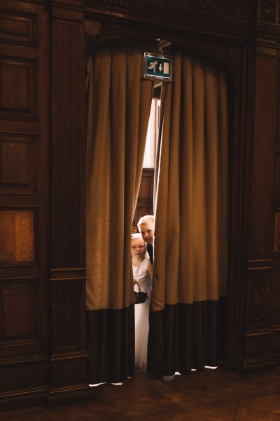 Father and bride take a peak at ceremony