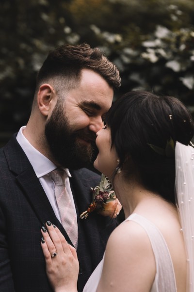 Bride and groom go in for a kiss in garden