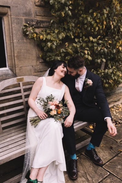 Bride and groom giggle/laugh on bench together