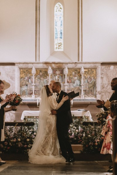 Bride and groom kiss at alter