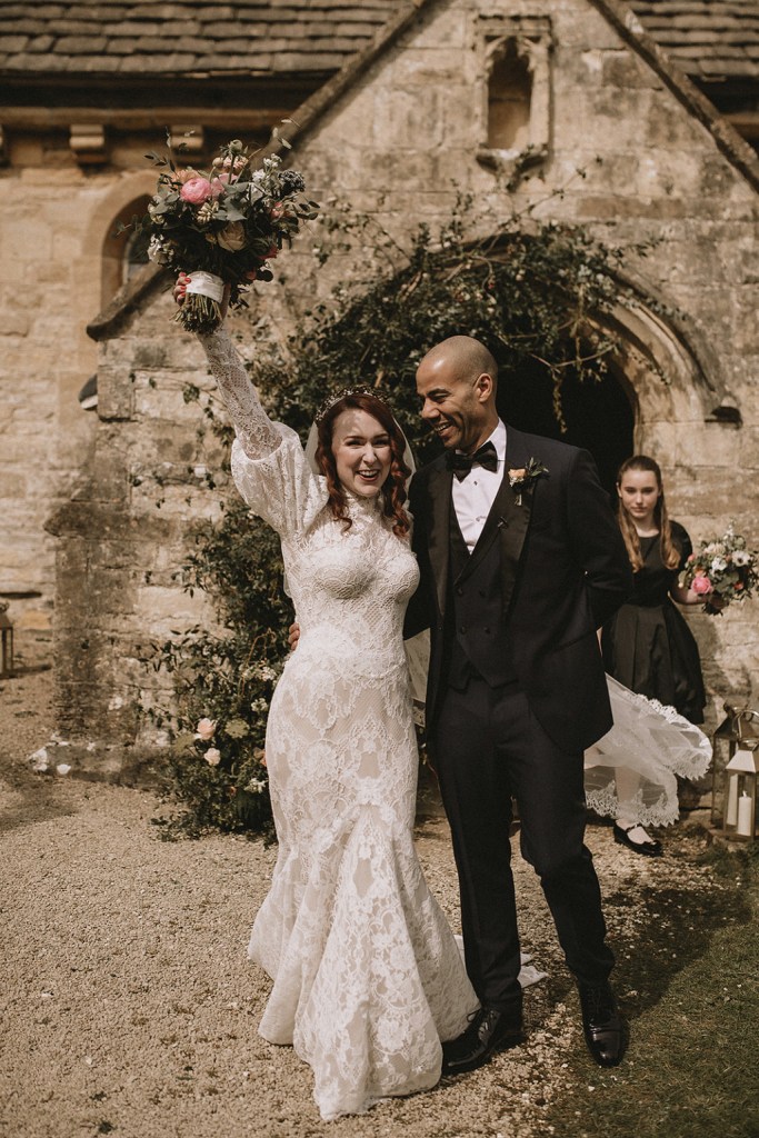 Confetti is thrown over couple bride and groom smile exterior church setting and guests