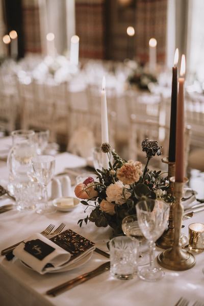 Table and chairs for guests roses flowers candles wine glasses