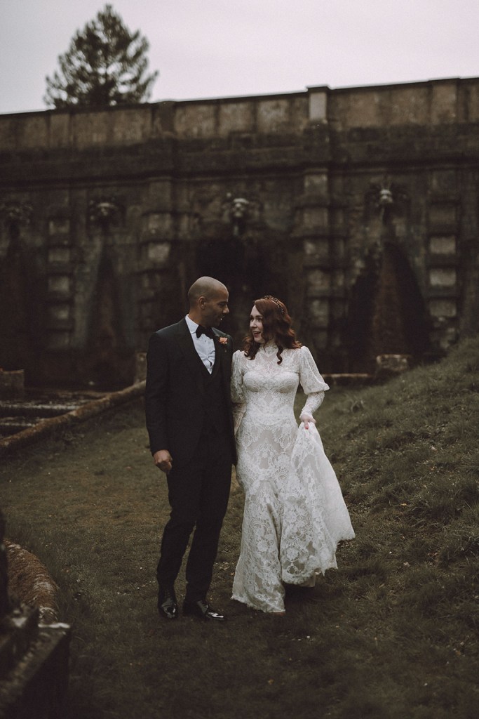 Bride and groom walking along the grass forest park setting