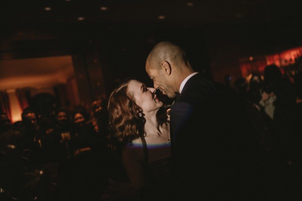 Dark photography bride and groom go in for a kiss